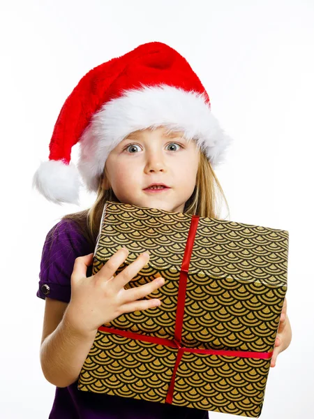 Cute little preschooler girl in red santa hat with gift box — Stockfoto