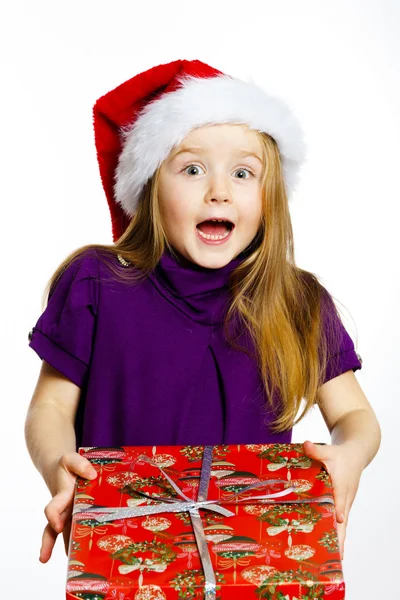 Cute little preschooler girl in red santa hat with gift box — Stok fotoğraf