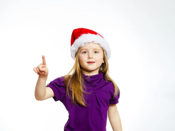Cute little girl in santa hat touching transparent screen — Stockfoto