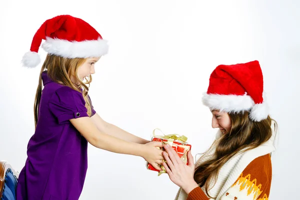 Two sisters in red sants hats with gift boxes — Stock Photo, Image