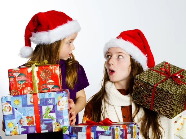 Twee zusters in rode sants hoeden met geschenkdozen — Stockfoto