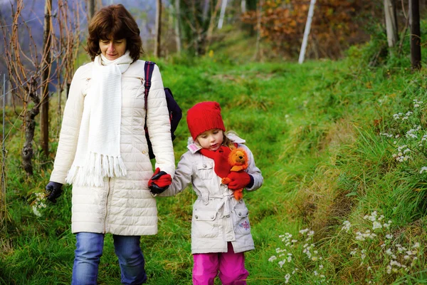 Linda niña caminando con su madre — Foto de Stock