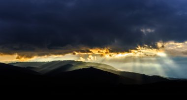 Güzel güneş ışınları aracılığıyla bulutlar dağlar üzerinde