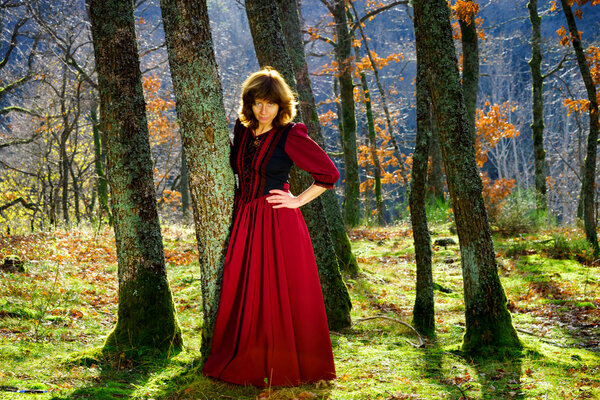 Woman in red renaissance dress portrait, autumnal forest, France