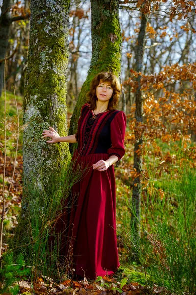 在红色连衣裙画像，秋季森林中的女人 — 图库照片