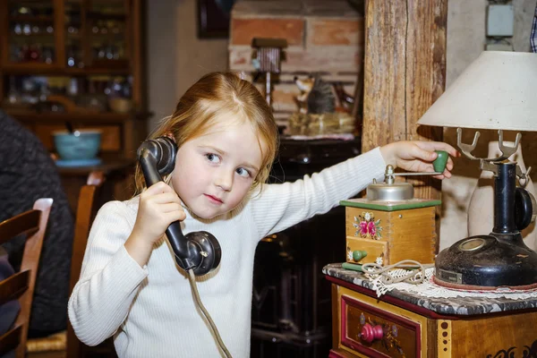 Roztomilý preschooler dívka mluví o staré vinobraní retro zásuvka telefonní — Stock fotografie