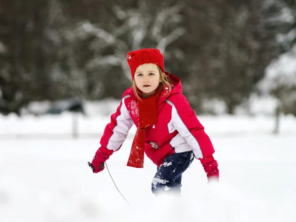 Mała dziewczynka gra z śniegu podczas snowflurry — Zdjęcie stockowe