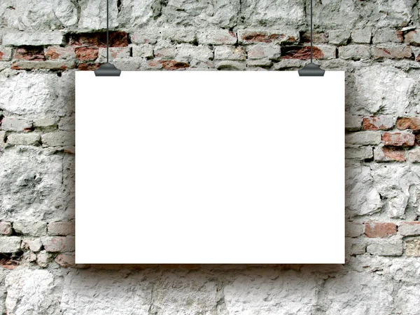 Singl pověsit horizontální papíru list s klipy na staré cihlové zdi — Stock fotografie