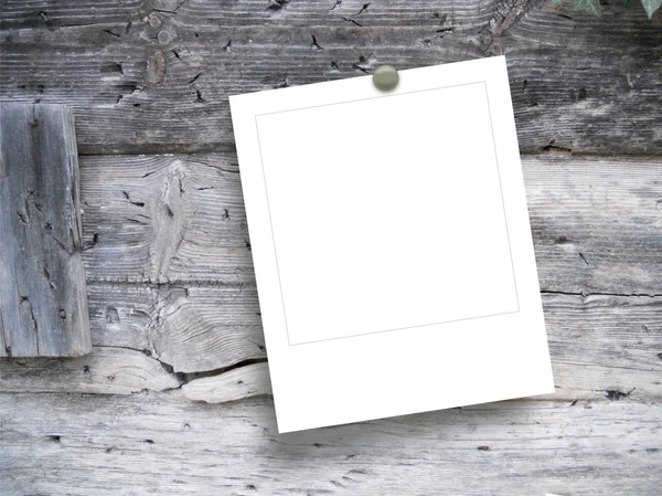 Marco de fotos instantáneo cuadrado en blanco único con pin en tableros y vigas de madera envejecidos — Foto de Stock