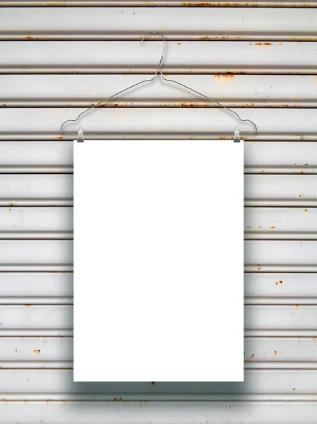 Single hanged paper sheet with clothes hanger on grey metal shutter — Stock Photo, Image