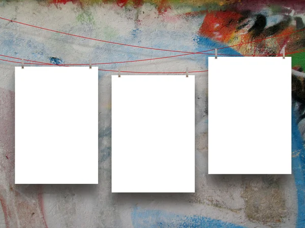 Three empty frames hanged by clothes pins on graffiti wall — Stock Photo, Image