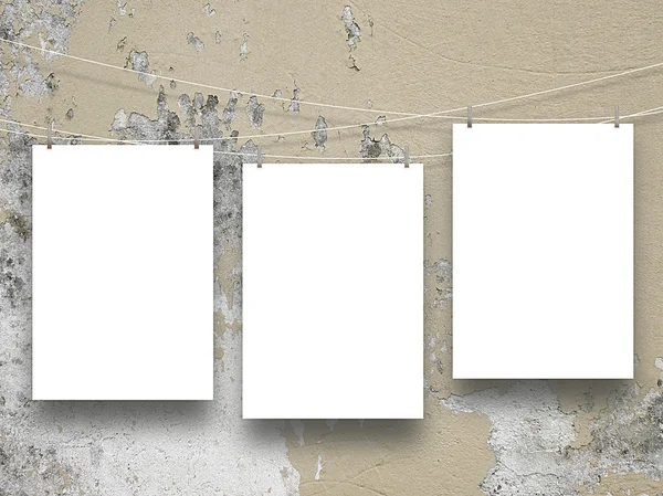 Tres marcos vacíos colgados por alfileres de ropa en pared de hormigón marrón claro rayado —  Fotos de Stock