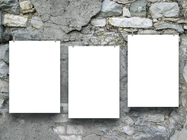 Tres marcos vacíos colgados por alfileres de ropa en la antigua pared de piedra agrietada y rayada —  Fotos de Stock