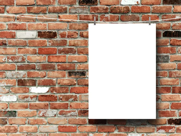 Close-up of one hanged paper sheet with pegs on red and brown brick wall — Stock Photo, Image