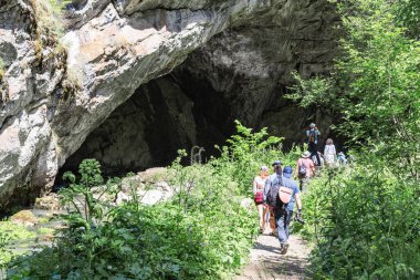 Dağda bir mağara. Bir grup turist tatilde mağaraya gidiyor. Konsept spor, turizm.