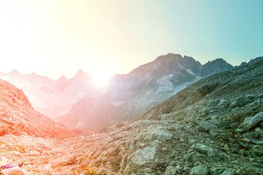 Parlak güneş dağın tepesinin arkasında saklanır. Tepeden manzara. Bulutsuz gökyüzü ve doğal uzay. İş düşüncesi, iyi bir fikir ya da mesaj. Temiz hava