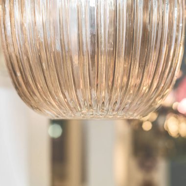 Tavandan sarı kahverengi camdan yapılmış kapalı bir tavan avizesi asılıyor. İç mekan dekorasyonu kavramı. İçeri gir. Kapat..