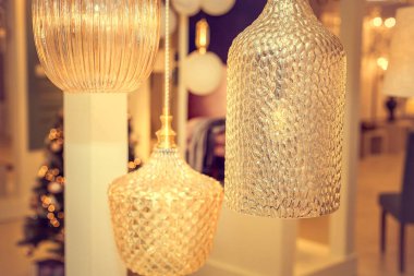 Bir grup kapalı tavan avizesi ve bir Noel ağacının arka planında şeffaf cam kaplama. Mutlu yıllar ve iç dekorasyon kavramı. İçeri gir. Kapatın. Sıcak ışık.