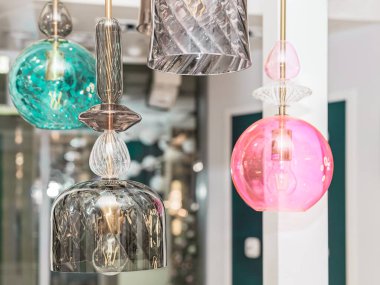 İç kısımda gri, turkuaz, pembe cam tavanlı bir grup kapalı renkli lamba asılıdır. Oda dekorasyonu kavramı. İçeri gir. Kapat..