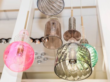 İç kısımda gri, turkuaz, pembe cam tavanlı bir grup kapalı renkli lamba asılıdır. Oda dekorasyonu kavramı. İçeride. Kapat..