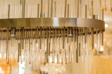 Tavana klasik bir avize monte edilir. Metal çerçeve sarı altından bir renktir. İç dekorasyon kavramı. İçeride. Kapat..