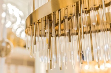 Tavana zarif, klasik bir avize yerleştirildi. Metal çerçeve sarı altından bir renktir. İç dekorasyon kavramı. İçeride. Kapat..