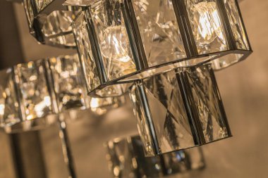 Cam tavan abajurundan parlayan lüks avizenin yakın çekimi. Modern bir iç mekanda klasik tarz. İçeri gir. Sıcak ışık.