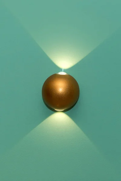 Eine Leuchtende Goldene Moderne Metall Led Lampe Der Türkisfarbenen Wand lizenzfreie Stockfotos