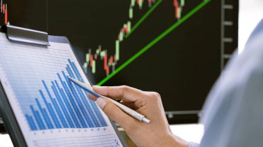 Formalite Giyimi Borsacısı Ofisteki ekranlarda analiz grafikleri, yatırım konsepti