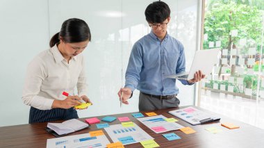 İşadamı masaya renkli notlar yapıştırarak yeni bir dava planlama fikrini paylaşmak için yeni bir proje üzerinde çalışıyor..