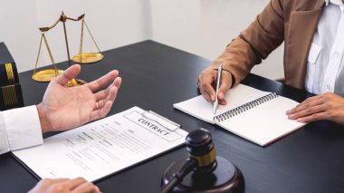 Avukat ya da yargıç müvekkil danışmanlığı ile toplantı sözleşmeli kağıt anlaşmasını tartışırken yardım