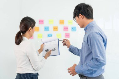 Toplantının iş ekibi çalışması ve ayna panosuna yapışkan bir yapışkan not. Ofis odasında ekiple beyin fırtınası planı toplamak için tartışıyorlar. 