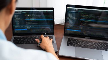 Programcı veya yazılım geliştirici Yeni Kod Satırları Yazıyor, kodlama teknolojileri ahşap endüstriyel iş yeri istasyonunda çalışıyor