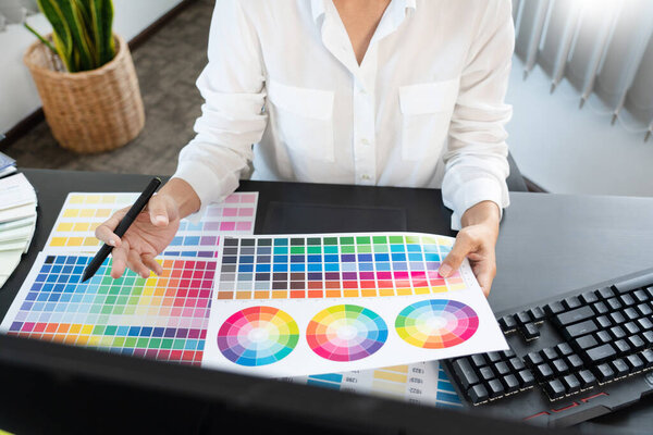 interior designer or creative graphic designer working on project architectural with colour samples with work tools and equipment for selection in office.