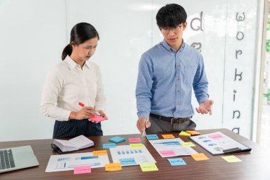 İşadamı masaya renkli notlar yapıştırarak yeni bir dava planlama fikrini paylaşmak için yeni bir proje üzerinde çalışıyor..