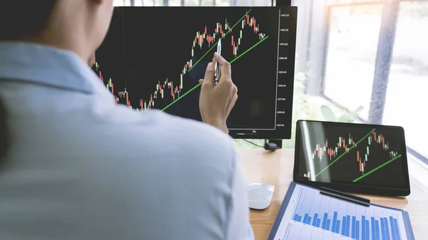 Stock Market Broker in formalwear Analyzing Graphs on  screens in the office, investment concept