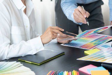 Grafik tasarımcısı veya yaratıcı birlikte çalışarak grafik tableti ve çalışma arkadaşı ile çalışma masasında bir stil kullanarak renklendirme