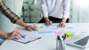 Genç işletme yöneticileri, ofis masasında ve modern dijital bilgisayarda yeni bir proje üzerinde çalışıyorlar..