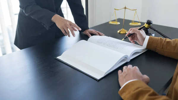 天秤座天秤和铁锤摆在桌上 两个律师正在讨论合同书 法律问题的决定 — 图库照片