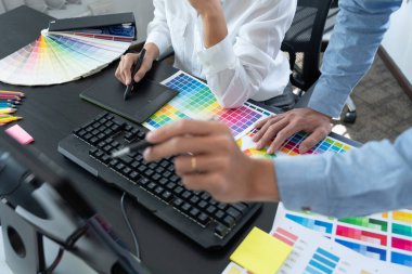 Grafik tasarımcısı veya yaratıcı birlikte çalışarak grafik tableti ve çalışma arkadaşı ile çalışma masasında bir stil kullanarak renklendirme