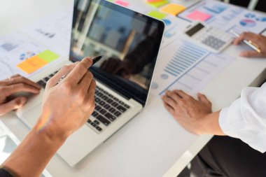 İş adamı finans müfettişi ve sekreteri rapor hazırlıyor ve iş arkadaşıyla birlikte modern bir çalışma alanında beyin fırtınası yapıyorlar..