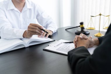 Hukuk, terazi ve çekiç masaya yatırıldı. İki avukat sözleşme kağıtları ve hukuk konularında tartışıyor..