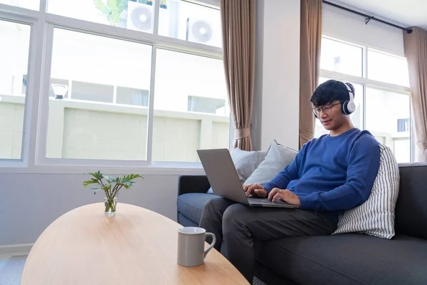 Jovem Atraente Asiático Homem Relaxante Confortavelmente Trabalhando Laptop Brilhante Sala — Fotografia de Stock
