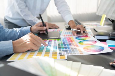 Grafik tasarımcısı veya yaratıcı birlikte çalışarak grafik tableti ve çalışma arkadaşı ile çalışma masasında bir stil kullanarak renklendirme
