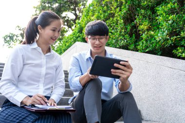 İş arkadaşları ofis binasının yakınında iş meselelerini tartışıyor, dışarıda birbirleriyle konuşuyorlar.