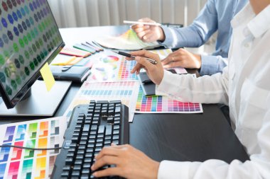 Grafik tasarımcısı veya yaratıcı birlikte çalışarak grafik tableti ve çalışma arkadaşı ile çalışma masasında bir stil kullanarak renklendirme