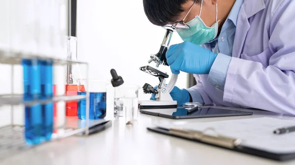 Młody Azjatycki Naukowiec Patrząc Przez Mikroskop Robi Badania Analizy Próbki — Zdjęcie stockowe