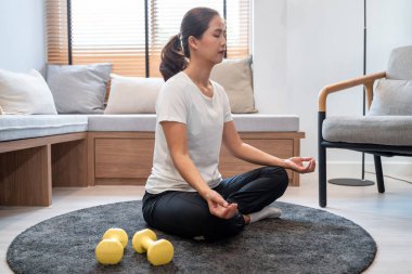 Zihnini sakinleştirmek için meditasyon yapan canlı bir kız ve evde rahatlamak için boş vakitleri var..