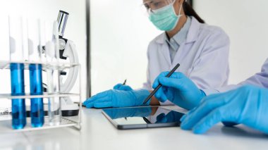 Laboratuvar önlüklü tıp araştırmacıları ya da araştırmacılar modern laboratuarda deneylerini test ediyorlar.