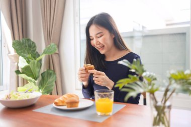 Yemek konseptinin olması, gülümseyen bir kadının yemek odasındaki en sevdiği tatlıları beğenmesi..